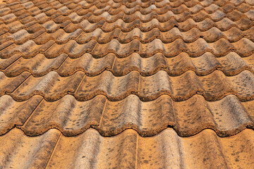 Close up of brown clay roof tiles. Red old dirty roof. Old roof tiles. Construction equipment build a house.