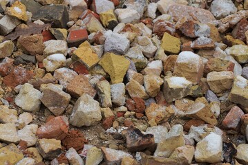 stone texture from pieces of old brown gray bricks in a heap on the street