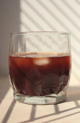 natural coffee with ice cubes and cream in a glass glass