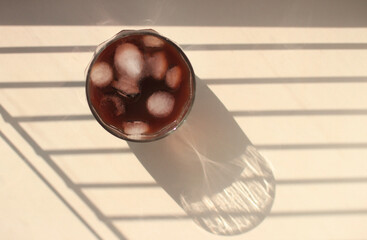 natural coffee with ice cubes and cream in a glass glass