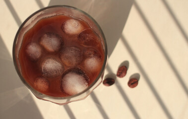natural coffee with ice cubes and cream in a glass glass