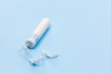 White tampon on the blue background, medical concept