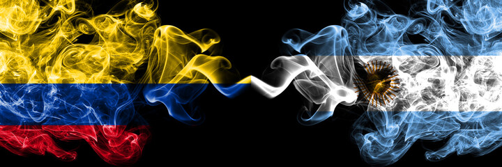 Colombia, Colombian vs Argentina, Argentinian, Argentine smoky mystic flags placed side by side. Thick colored silky abstract smokes flags.