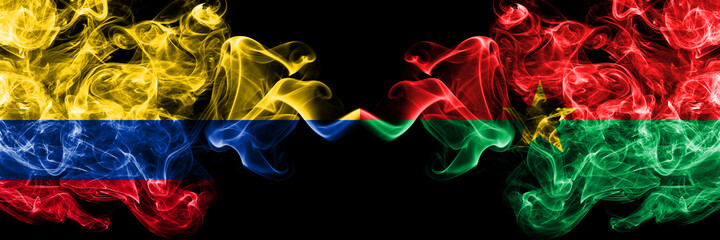 Colombia, Colombian vs Burkina Faso, Burkinese smoky mystic flags placed side by side. Thick colored silky abstract smokes flags.