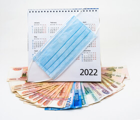 Medical mask and calendar 2022. The mask on the calendar and Russian money. Calendar 2022 and paper Rubles.