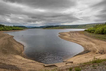 Rolgordijnen Low water level on a UK reservoir. Water shortage in drought conditions © Matt