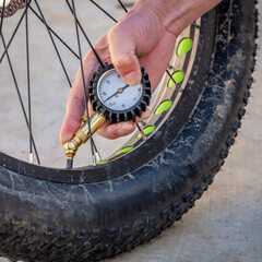 Bike mechanic uses an air gage to check bike tire processor