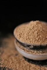 Maca  powder in ceramic cups set on black background. Peruvian ginseng.peruvian Maca powder close-up. Super food. Natural energetic. Healthy natural products.  