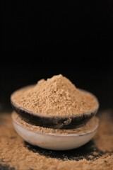 Maca  powder in ceramic cups set on black background. Peruvian ginseng.peruvian Maca powder . Super food. Healthy natural products.  Lepidium meyenii