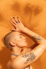 Fototapeta premium Woman with jewelry posing fashionably with closed eyes and hands near her head