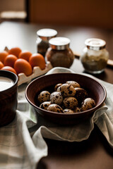 Quail eggs in a clay plate on a dark background