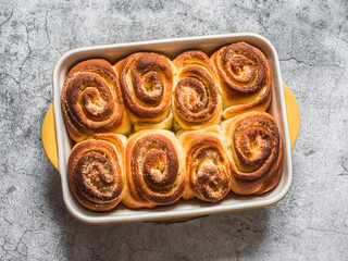 Lemon sugar swirl buns in a baking dish on a grey background, top view