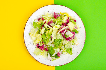 Light dietary vegetarian salad in plate on bright background. Healthy lifestyle concept