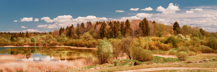 Fototapeta premium Wide angle large panoramic view on wooded hill and small lake at sunny day
