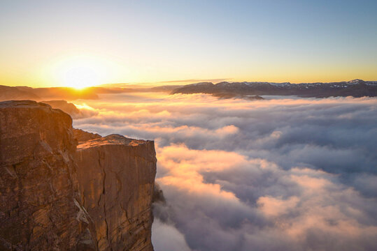 Pulpit Rock mountain sunrise over cloud covered ocean fjord