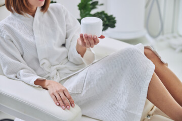 Beautiful charming female relaxing in cosmetologist cabinet