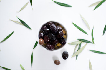 olive oil and olives over white table
