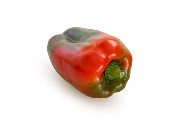 A red-green bell pepper, laying on a flat surface, isolated on white background with a clipping path.