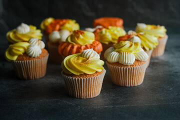 Delicious muffins. Orange and lemon cream muffins. Cupcakes on a concrete table 