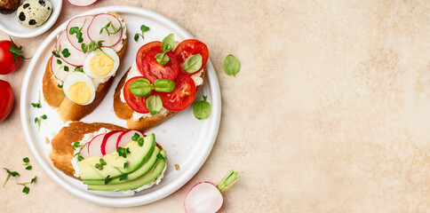 Sandwiches with avocado, radishes, cherry tomatoes, quail eggs, micro greens and cream cheese.  Healthly food. Top view. Copy space