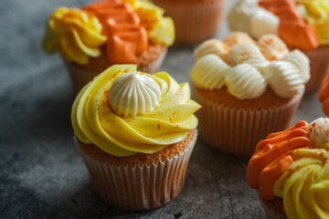 Delicious muffins. Orange and lemon cream muffins. Cupcakes on a concrete table 