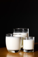 Copy space of three glasses of milk on a black background