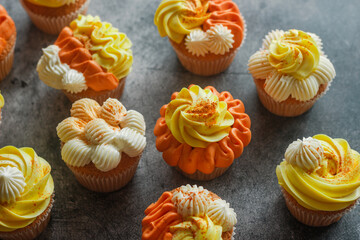 Delicious muffins. Orange and lemon cream muffins. Cupcakes on a concrete table 
