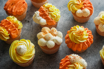 Delicious muffins. Orange and lemon cream muffins. Cupcakes on a concrete table 
