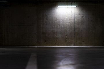 Empty parking lot with an overhead dim light, underground parking garage