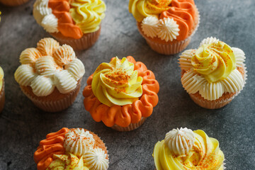 Delicious muffins. Orange and lemon cream muffins. Cupcakes on a concrete table 