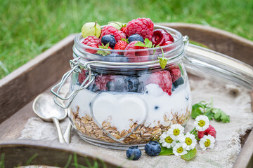 Muesli with fruits in garden. Healthy and slim diet.