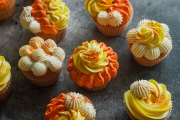 Delicious muffins. Orange and lemon cream muffins. Cupcakes on a concrete table 