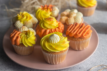 Delicious muffins. Orange and lemon cream muffins. Cupcakes on a concrete table 