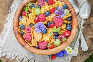 Cornflakes with fruits and flowers. Fit breakfast.