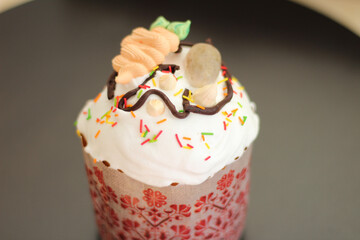 Freshly prepared Easter cakes in paper forms, decorated with fondant, chocolate icing and sugar eggs and carrots