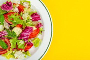 Light dietary vegetarian salad in plate on bright background. Healthy lifestyle concept