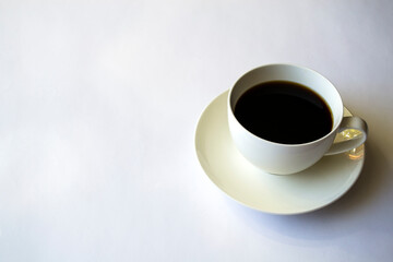 Morning coffee in a white cup on a white saucer.