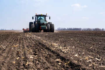 tractor with seeder in the field in early spring