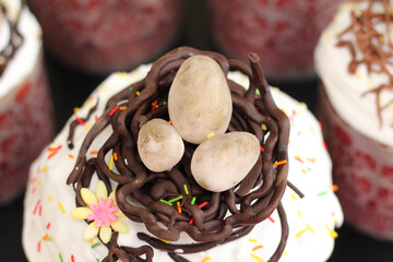 Sugar eggs in chocolate nests on freshly baked Easter cakes