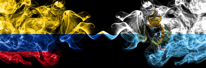 Colombia, Colombian vs San Marino smoky mystic flags placed side by side. Thick colored silky abstract smokes flags.