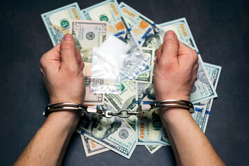 Man in handcuffs with money and drugs on dark background. The concept of punishment for possession, distribution and use of drugs. Concept no to drugs