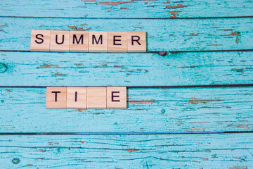 Top view summer time lettering of alphabet wooden blocks on pink background