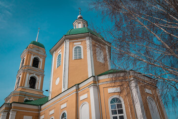 orthodox church and birch branches on a blue sky background
