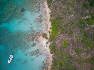 A top view shot of a boat on the blue sea near the seashore