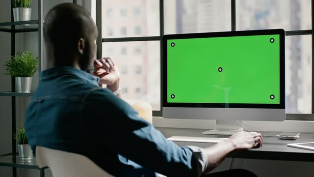 Black man freelancer with crew haircut works on computer