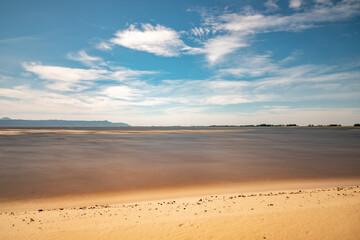 Fototapeta na wymiar Sand, clouds and lake with blue sky