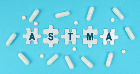 On a blue background, there are pills and puzzles with the inscription - ASTMA