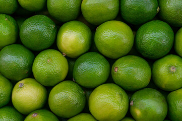 Lime citrus fruits in the fruit market. Texture  juicy green tropical lime fruit. Image green limes