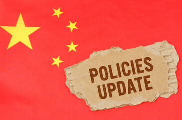 Against the background of the Chinese flag lies cardboard with the inscription - Policies Update