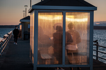 Silhouettes in a shelter reflect on a golden sunset